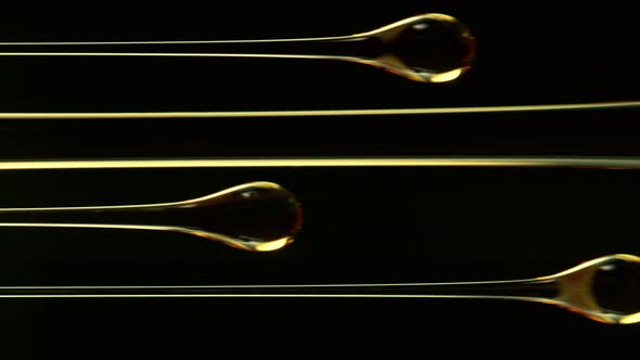 Super Slow Motion Shot of Golden Oil Drops Collection Isolated on Black Background at 1000fps