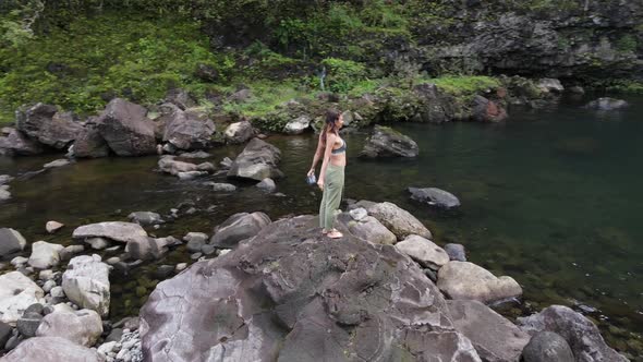 Aerial View of Beautiful Girl at the Waterfall on the Island of Hawaii