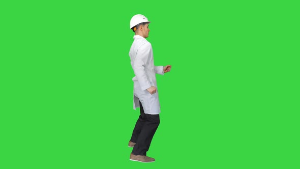 Young Workman with Helmet in White Robe Enjoy Dancing on a Green Screen, Chroma Key