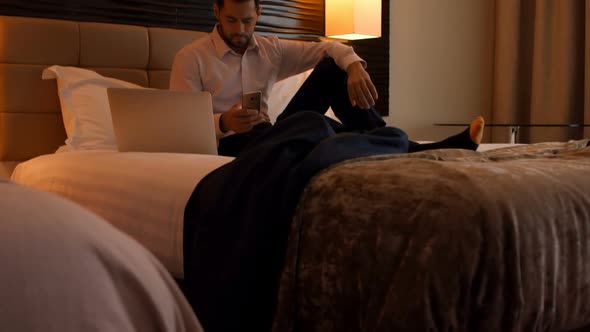 Businessman using mobile phone in bedroom 4k