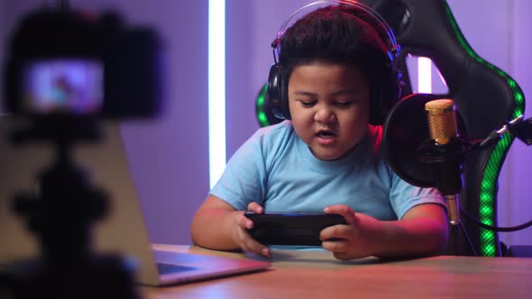 Excited Asian Little Boy Playing Video Game With Mobile Phone While Live Stream