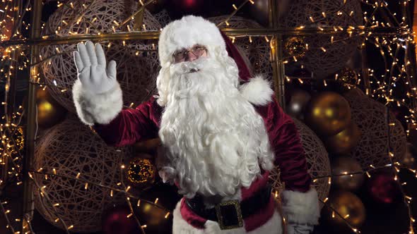 merry santa claus waving his hands and recording a virtual greeting on christmas eve