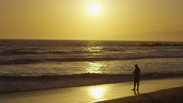 Man on the beach at sunset