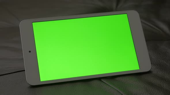 Green screen tablet PC on leather sofa 4K 2160p panning UHD footage - Smart touch screen device with