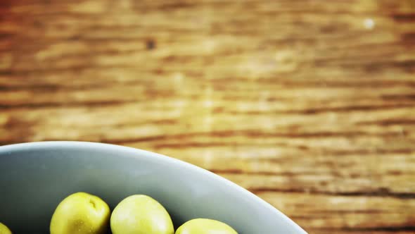 Fresh green olives and rosemary in a bowl