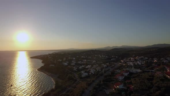 Aerial Sunset Scene of Sea and Coastline with Houses in Trikorfo Beach, Greece