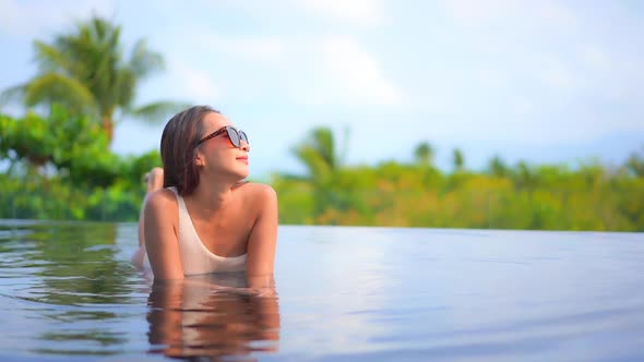 Young asian woman enjoy around outdoor swimming pool for leisure