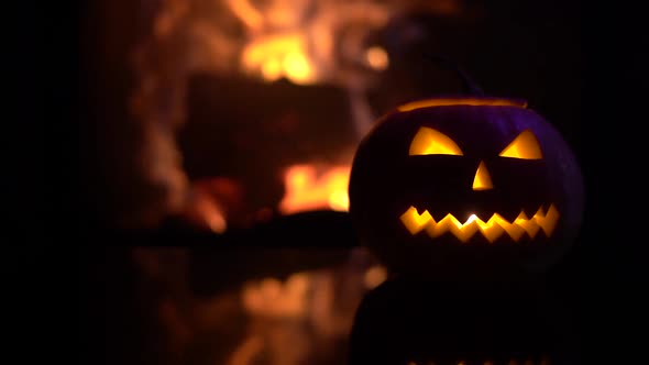 Creepy halloween pumpkin near a fireplace. Fire on the background.