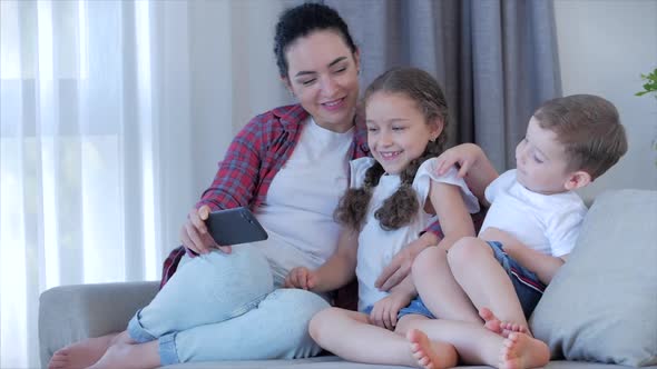 Happy Family,mom and Cute Little Children Watch the Phone,mom Plays with Children at Home,relaxing