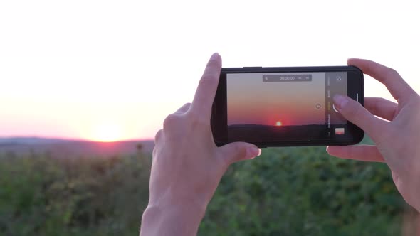 A Girl Capture the Beautiful Sunset Moment with Her Smartphone