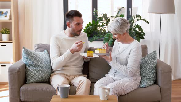 Senior Mother and Adult Son Eating Cake at Home