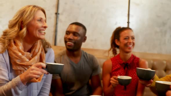 Group of happy friends interacting while having coffee 4K 4k