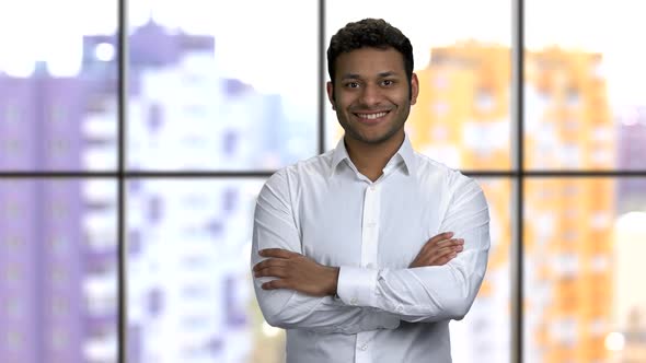 Brownskinned Man with His Arms Crossed Pointing Left with His Finger