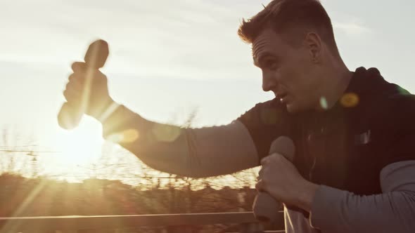 Young and fit man having evening workout outdoor. Urban sunset background.