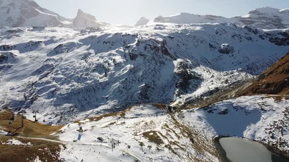 the beautiful Schwarzsee (black-lake) in the snow-capped swiss mountains, drone