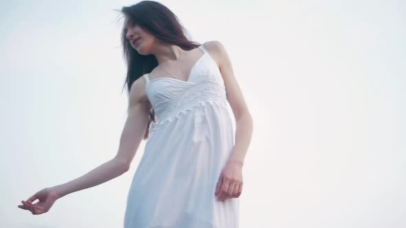 tender sensual spring fashion portrait of a beautiful happy young woman in white dress with long bro