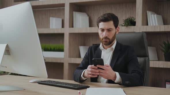 CEO in His Office Working on the Phone and Looks Serious and Concentrated