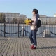 A Middleaged Woman Brunette with a Bouquet of Yellow Leaves Walks Along the City Embankment - VideoHive Item for Sale