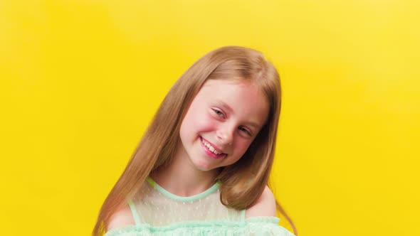 Kid Quite Smiling Happily with Blond Hair Looking with Satisfaction in Front of the Camera