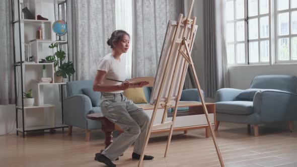 Asian Artist Girl Coming To Sit And Holding Paintbrush Painting On The Canvas