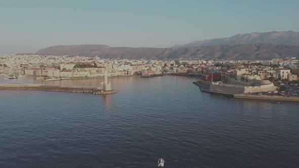 Chania Old Port lighthouse sunset aerial view drone zoom out