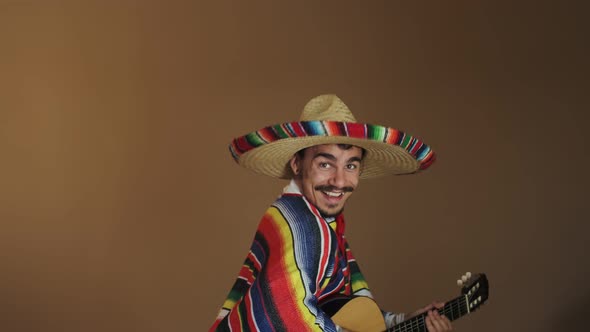 Young Mexican In National Costume Playing Guitar
