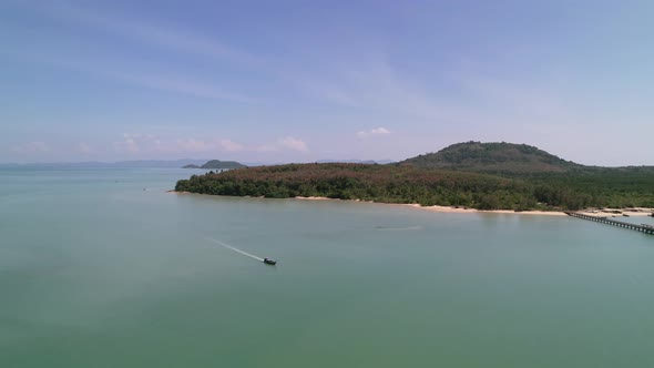 aerial circling thai longtail boat traveling around coconut island in the andaman sea of thailand