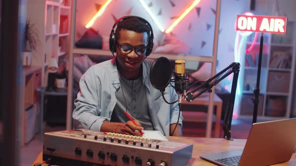 Young Afro-American Man Recording Podcast in Home Studio