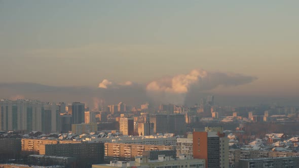 City Pipes Emit Steam Into the Arctic Atmosphere Against the City Skyline