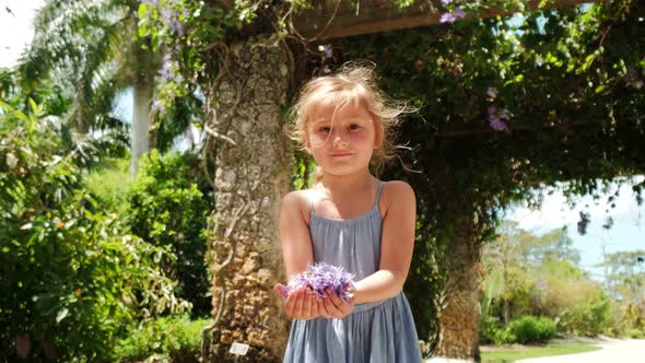 Slow Motion of Beautiful Happy Girl Throwing Flower Petals and Smiling at Camera