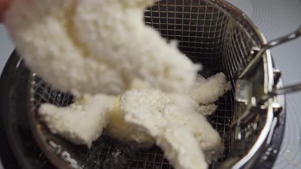 Frozen Shrimp in Batter is Placed in a Deep Fryer Basket
