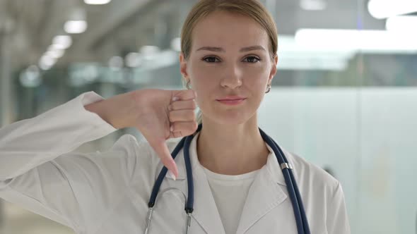 Portrait of Disappointed Female Doctor Doing Thumbs Down 