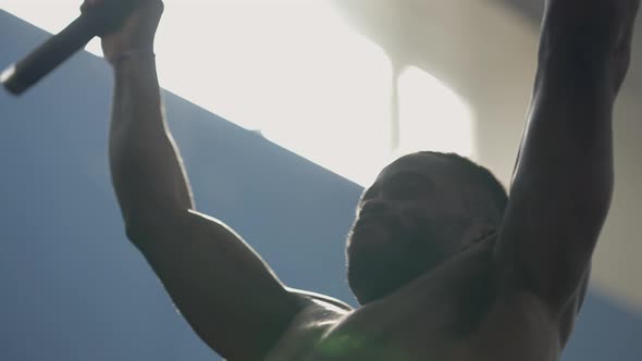 Strong African American Sportsman Doing Pullups in Backlit Indoors