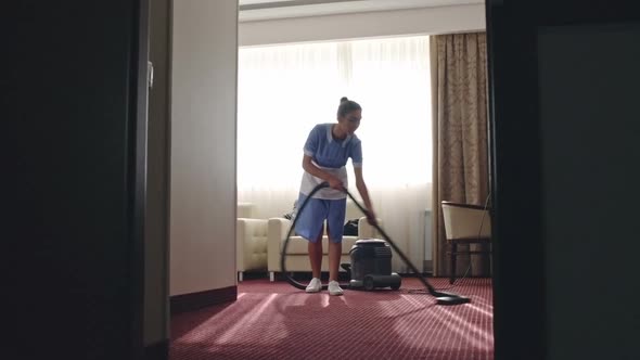 Housemaid Vacuuming Hotel Room