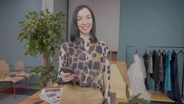 Portrait of Beautiful Smiling European Woman Fashion Designer Standing in Atelier Posing for Camera