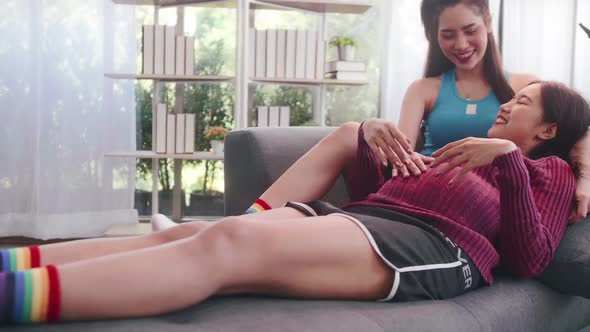 Pregnant Asian lesbian woman and her partner are happy to spend time together at home.