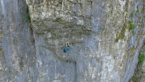 Aerial view of a man rock climbing up a mountain