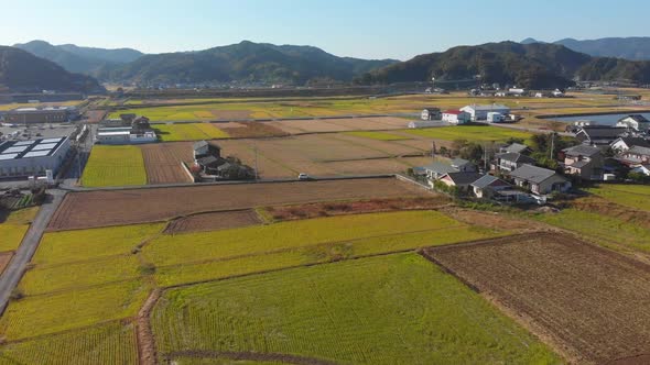 flying over a small town and its fields in japan
