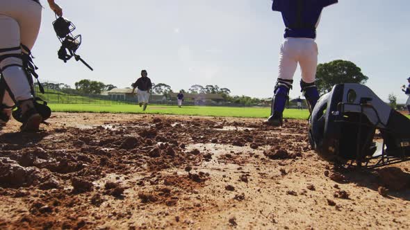 Diverse group of female baseball players, fielder attempting to catch running hitter at base