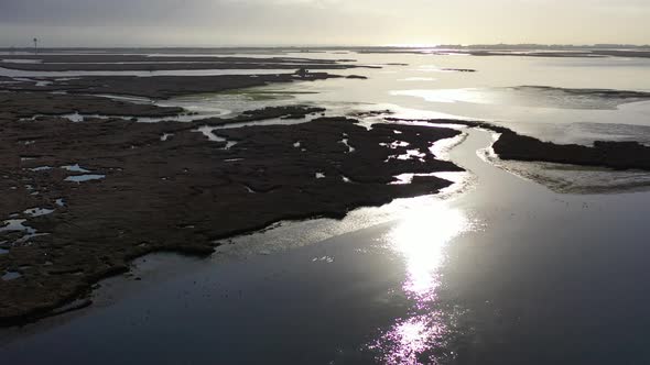 An aerial shot over Baldwin Bay near Freeport, NY during sunset. The camera tilt down & dolly in ove