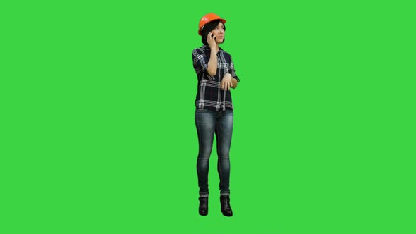 Young Attractive Asian Engineer Woman Standing Having a Phone Call on a Green Screen