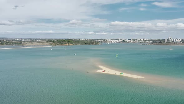 Sportsmen Riding Kiteboards with Parachutes on Waves of Atlantic Ocean Alvor