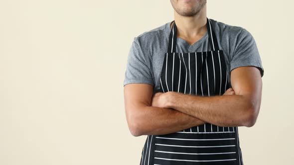 Smiling waiter gesturing against beige background 4k