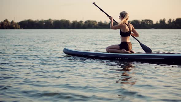 Woman Meditating Pose Sup Board On Vacation.Cross-Legged No Stress Leisure Surfing Boat Fitness.