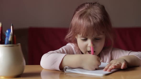 Cute Child Girl Artist Studying Drawing Picture with Pen and Pencils at Home