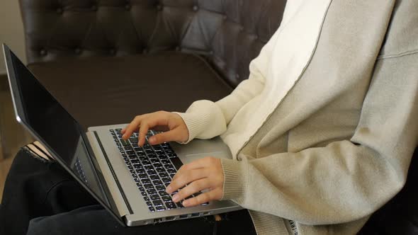 A Girl Works on a Laptop in a Cafe