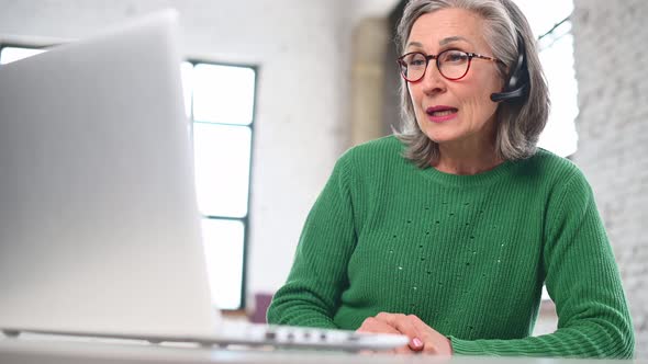 Mature Senior Woman Is Using a Laptop for Video Call at Home