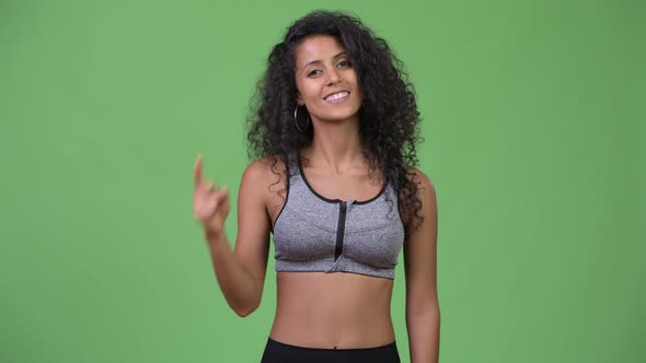 Young Beautiful Hispanic Woman with Gym Clothes Pointing Up