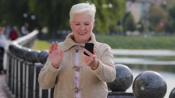 Happy Senior Woman of Retirement Age Making Video Call Looking at Smartphone Camera