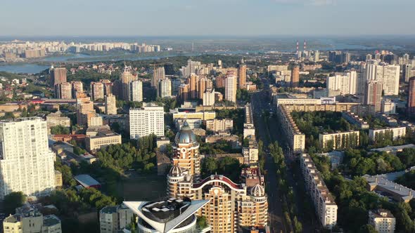 Aerial drone video of downtown apartment buildings, Dnipro river, and cars on the highway in Pechers